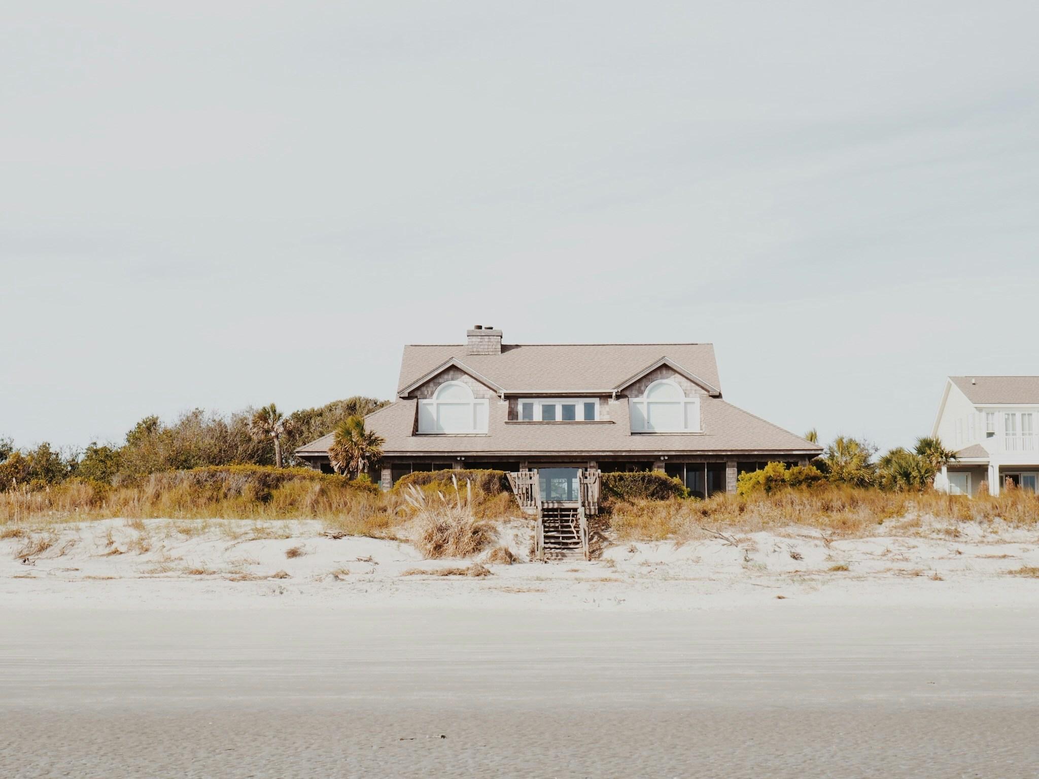 Beach house with arched windows overlooking dunes and sand